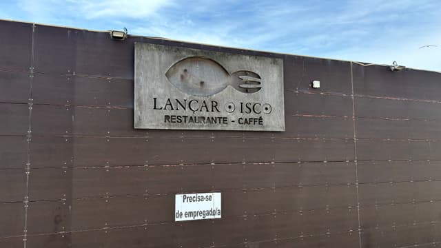 A building exterior with a sign for Lancar - Ise featuring a fish logo, indicating a restaurant and café